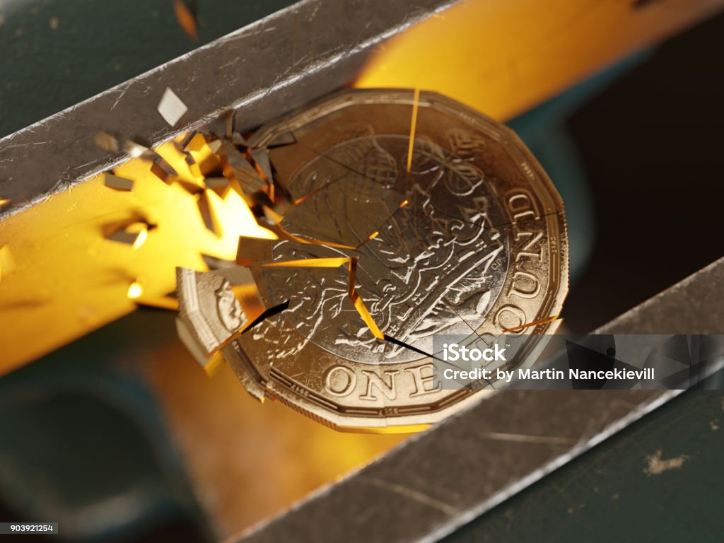 British pound coin held by a vice/clamp Close-up of the a British pound coin held by a bench vice or clamp. Coin Stock Photo