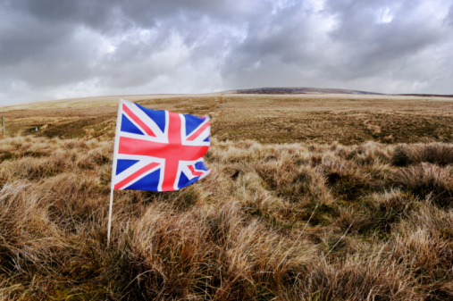 union jack blowing in the wind on a hillside