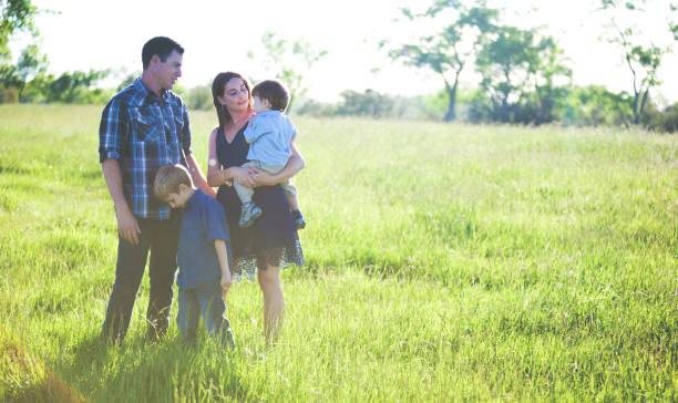 istock Young Mother Father and Sons Outdoors in Summer Having Fun Playing 903925652
