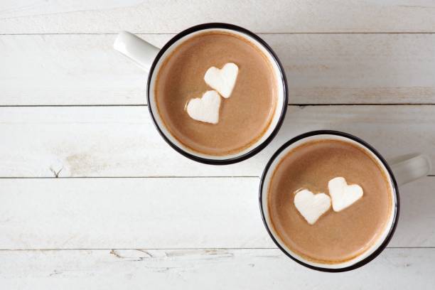 Hot chocolate with heart marshmallows over white wood Two cups of hot chocolate with heart shaped marshmallows over a white wood background hot chocolate stock pictures, royalty-free photos & images