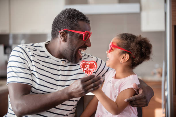 istock Mixed race Father and daughter taste lollipop during Valentine's Day 903926438