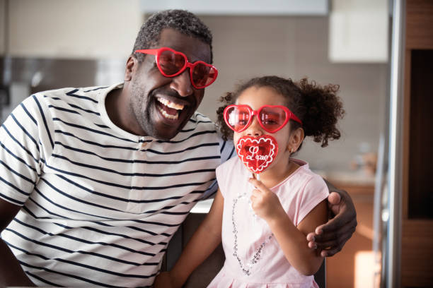 istock Mixed race Father and daughter taste lollipop during Valentine's Day 903926748