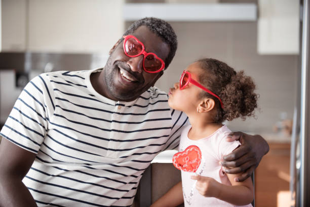 istock Mixed race Father and daughter taste lollipop during Valentine's Day 903926870