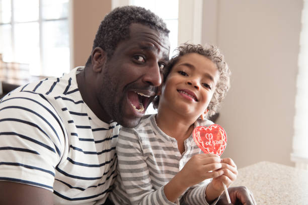 istock Mixed race Father and son taste lollipop during Valentine's Day 903927548