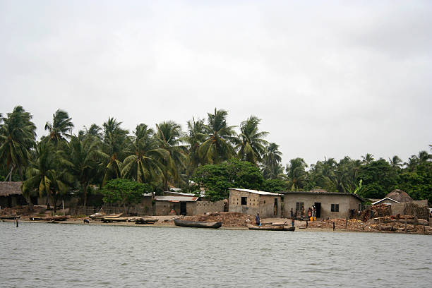 Calm river with semi-abandoned village on riverbank in summer