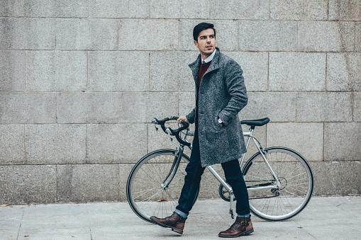 Elegant man with a bicycle walking around the city.