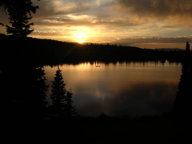 istock Dark Sunset over lake with canoe 903953236
