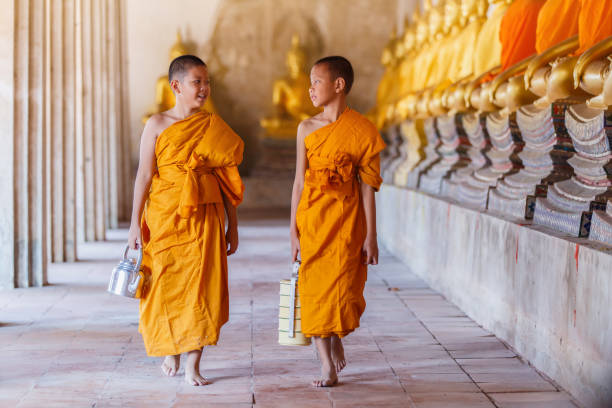 istock Two novices monk walking and talking in old temple 903956366
