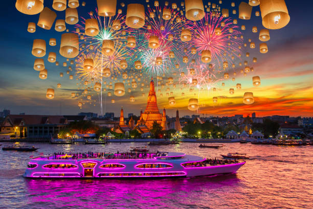 flottant de lampe et de feux d’artifice à wat arun et cruise ship dans le temps du coucher du soleil en vertu de la célébration du nouvel an - arun photos et images de collection