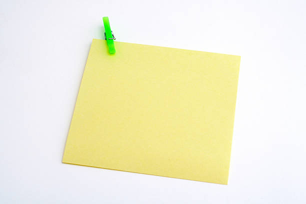 istock isolated yellow paper with green clamp on white background 90395766