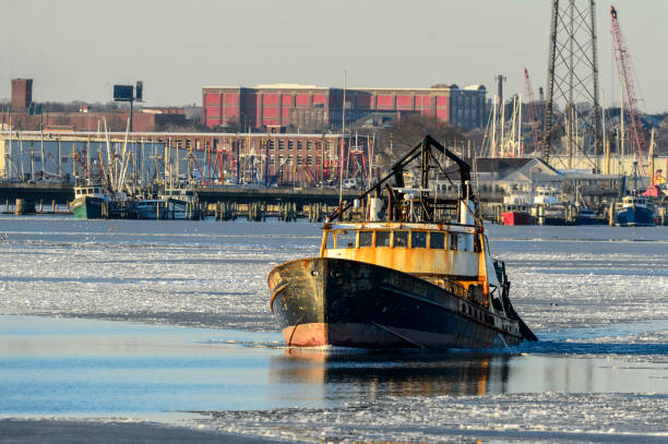 New Bedford, Massachusetts, USA - January 10, 2018: Fishing boat Wando River leaving icy New Bedford harbor after break in bomb cyclone weather pattern