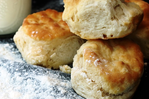 Stack of three buttermilk handmade biscuits from scratch with flour