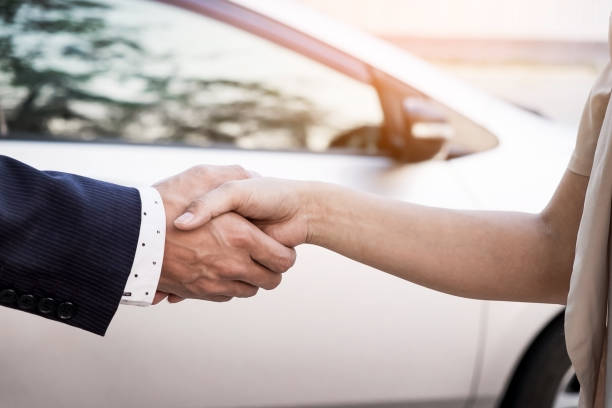 istock Cropped Image Of Salesman Doing Handshake With Customer Against Car 903964100