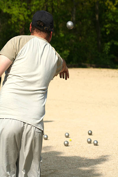 Man plays petanque, french game. stock photo