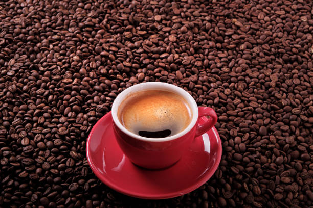istock Red coffee cup with espresso and roasted beans background 903977352