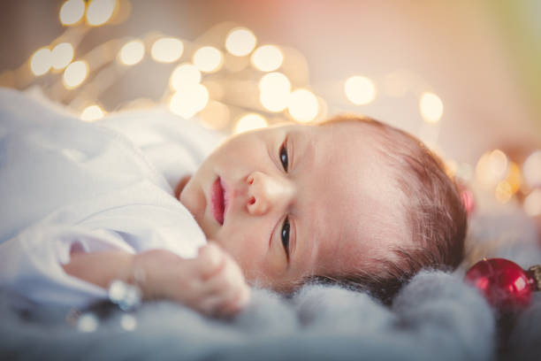 istock Little infant with Christmas baubles around 903981372