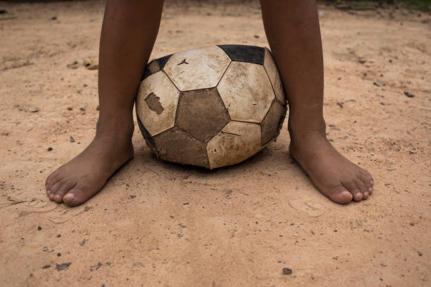 istock Low Section Of Child With Ball On Dirt Road 903984716