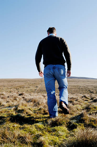 istock Man walking up rural hill mountain 90398512