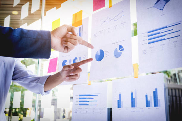 istock Cropped Hands Of Business People Pointing At Graphs In Office 903988574