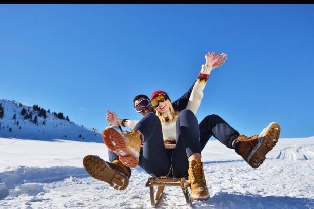 istock Young Couple Sledding And Enjoying On Sunny Winter Day 903996258