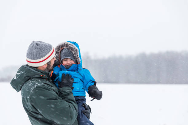istock Father and Son Playing Outdoor in Winter Forest Snowstorm 903999620