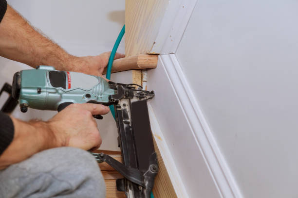istock Carpenter brad using nail gun to Moulding trim, with the warning label that all power tools 904008482