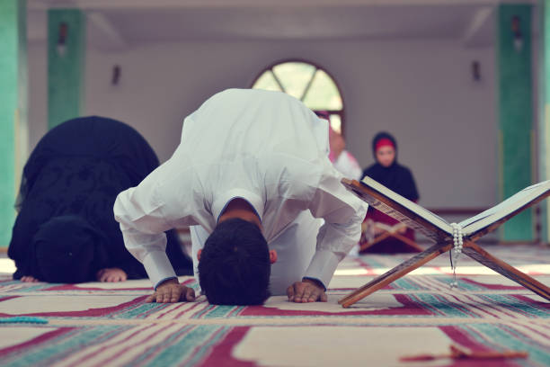 istock Muslim man and woman praying in mosque 904011272