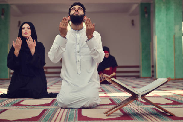 istock Muslim man and woman praying in mosque 904011782