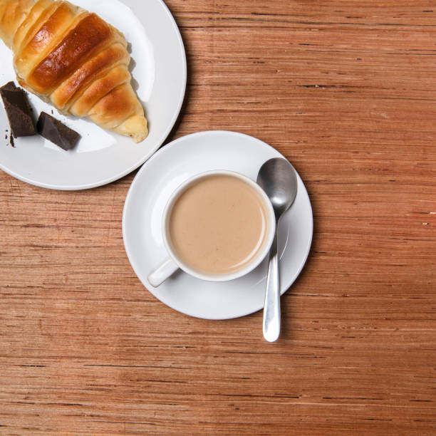 istock Coffee and croissant on wood background. 904011824