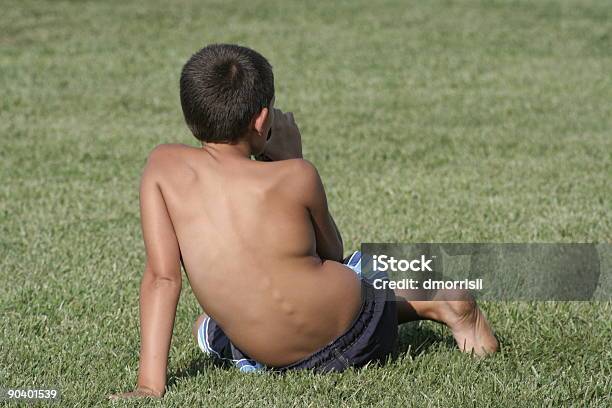 Jovem Rapaz Sentado Na Grama Com Bebidas - Fotografias de stock e mais imagens de Rapazes - Rapazes, Costas, Criança
