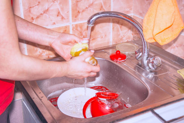 girl washes the dishes in the sink - sink domestic kitchen kitchen sink faucet imagens e fotografias de stock