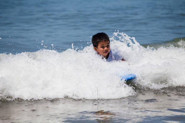 istock Kid enjoying swimming with bodyboard. 904025946