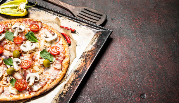 istock Fresh pizza with mushrooms, bacon and tomatoes. 904026082