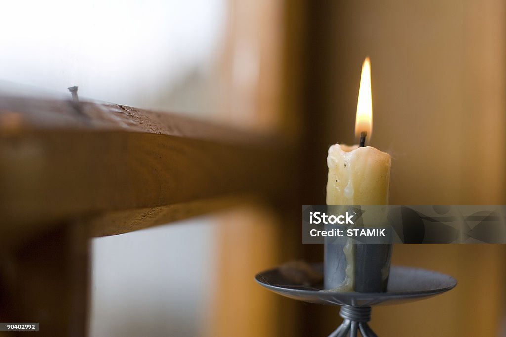 A lighted candle stick near a window  burning candle by window Window Stock Photo