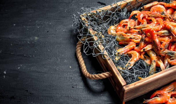 istock Fresh shrimp in a fishing net on a tray. 904032204