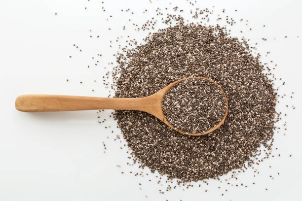 Chia seeds in wooden spoon on white background