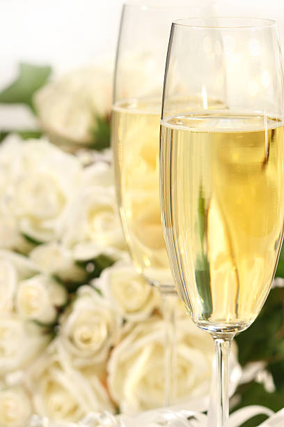 Champagne glass close-up with a bouquet of roses stock photo