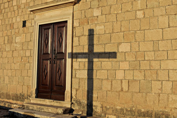 architecture details/ Shadow of a cross on a house wall