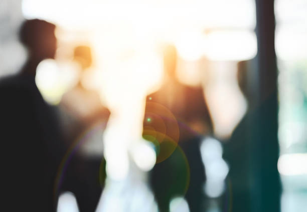 Keeping their focus on success Defocused shot of a group of businesspeople having a discussion in an office business people silhouette stock pictures, royalty-free photos & images