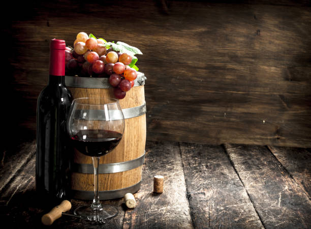 istock barrel of red wine with grapes and a corkscrew. 904052520