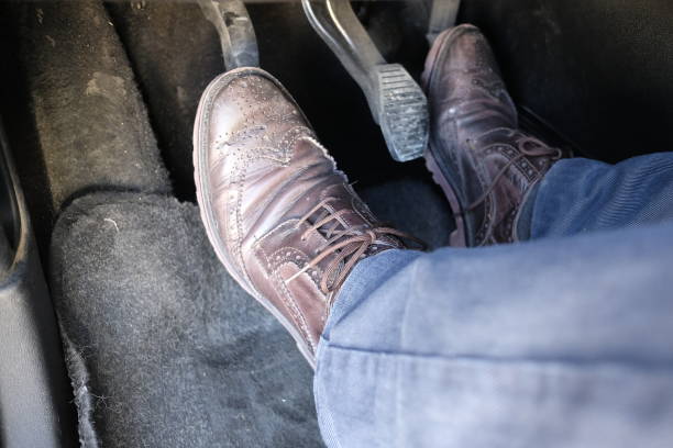 Low section of unrecognizable young woman in jeans walking into a taxi, about to sit on the back seat.