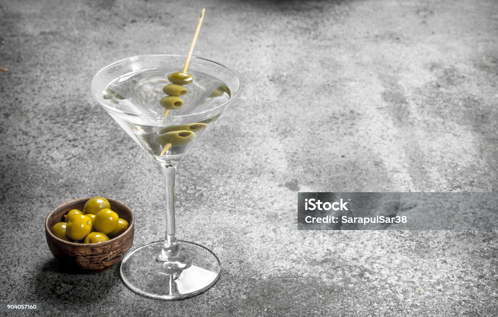 Martini with olives. Martini with olives. On a rustic background. Alcohol - Drink Stock Photo