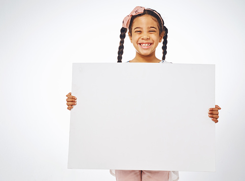 Studio shot of an adorable little girl holding a blank placard