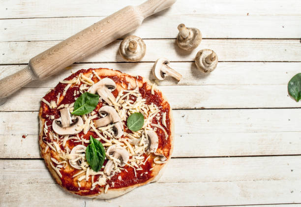 istock Preparation of pizza with various ingredients. 904069654