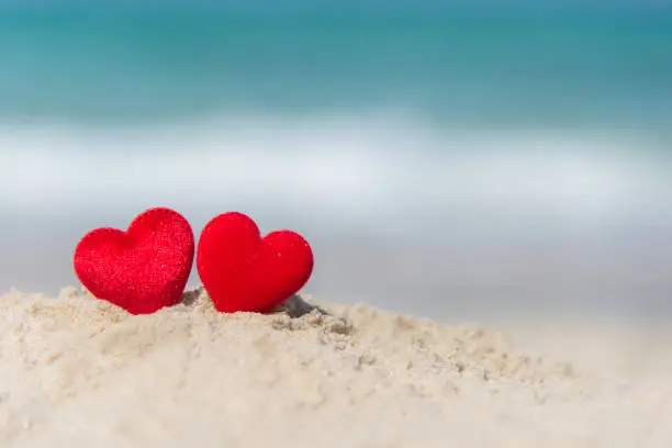 Photo of Two red hearts on the summer beach.  Valentine Day.