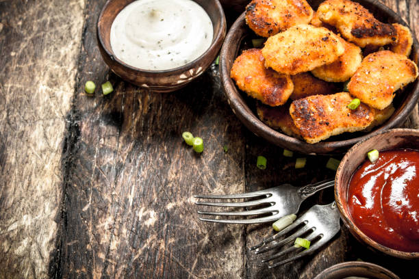 Chicken nuggets with various sauces. Chicken nuggets with various sauces. On a wooden background. heathy snack stock pictures, royalty-free photos & images