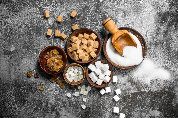 Different kinds of sugar in bowls. Different kinds of sugar in bowls. On a rustic background. sugar stock pictures, royalty-free photos & images