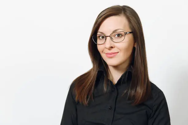 Beautiful happy caucasian young smiling brown-hair business woman in black classic shirt and glasses isolated on white background close up. Manager, worker, student. Copy space for advertisement