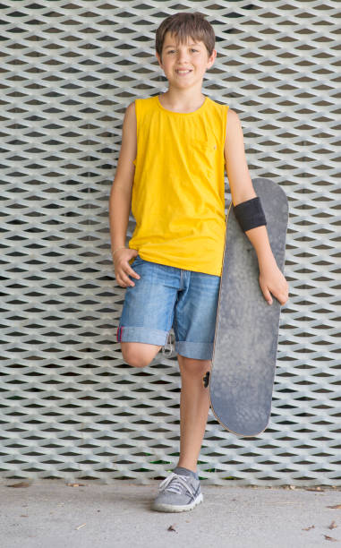 istock A teenage boy carrying skateboard and smiling 904075152