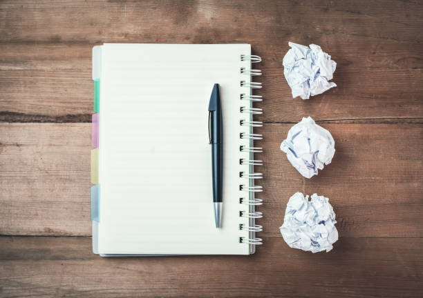 istock Notepad with pen and crumpled papers on a wood desk. 904077898